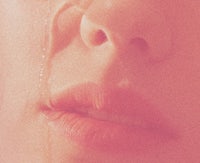 a close up of a woman with a tear on her face