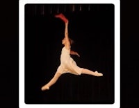a dancer in the air with a red scarf