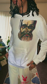 a man wearing a white hoodie with a beard