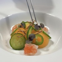 a white plate with cucumbers and shrimp in it