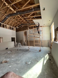 a man is working on the ceiling of a room that is under construction