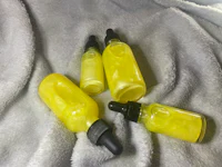 three bottles of yellow liquid sitting on a blanket
