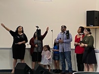 a group of people singing in front of a microphone