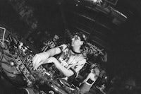a black and white photo of a dj at a party