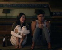 a man and woman sitting next to each other at night