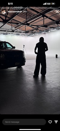 a person standing in front of a car in a garage