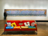 a woman standing in front of a colorful couch