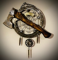 a steampunk dream catcher with an axe and gears