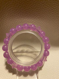 a purple bead ring hanging on a mirror