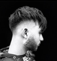 a black and white photo of a man with a faded haircut