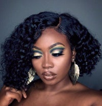 a black woman with green eye makeup and curly hair