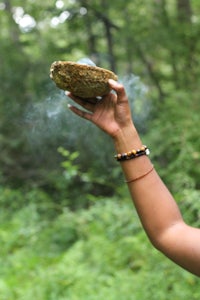 a woman holding a rock in the forest