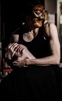 a man with a mask on his head is being held by another man