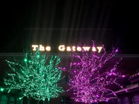 the gateway is lit up at night with green and purple lights