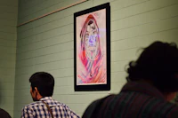 a group of people looking at a painting on a wall