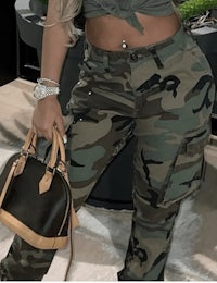 a woman is posing in camouflage cargo pants