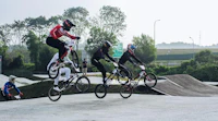 a group of people doing tricks on their bikes in a park