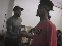 two men standing next to each other in a room