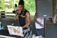 a man with dreadlocks singing into a microphone