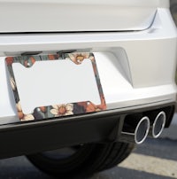 a white car with a floral license plate frame