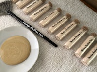 a plate with several tubes of foundation and a brush