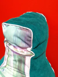 a green hooded pillow on a red background