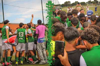 a group of soccer players in green uniforms congratulating each other