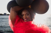 a woman in a red dress holding balloons