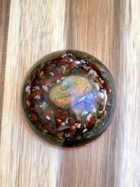 a red and green stone on a wooden table
