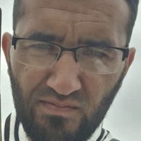 a man with glasses and a beard is holding a stick