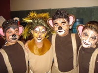 four boys in lion costumes posing for a picture