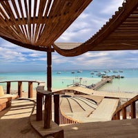 a wooden deck with a view of the ocean and boats