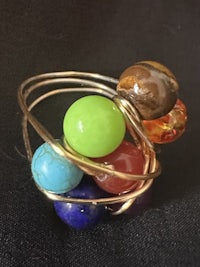 a gold ring with multi colored stones in it