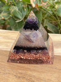 an amethyst crystal pyramid on a wooden table