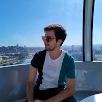 a man sitting on top of a ferris wheel with a view of a city