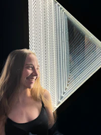 a woman is sitting on a bed in a room with a light