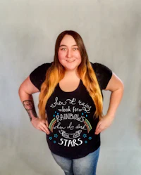 a woman wearing a black t - shirt with a rainbow on it
