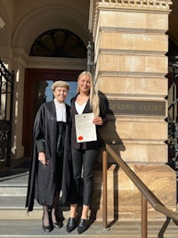 two women standing on the steps of a court