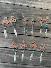 a group of earrings with feathers and turquoise beads