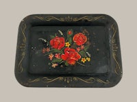 a black tray with roses painted on it