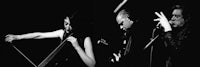 a black and white photo of two people playing instruments