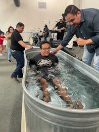 a man is being baptized in a tub