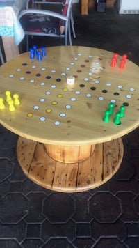 a wooden board game table with colorful pieces on it