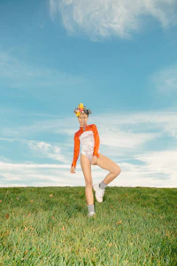 a girl is standing on a grassy field with a frisbee