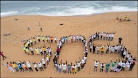 a group of people standing in front of a beach