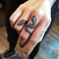 a woman's ring with a snake tattoo on it