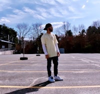 a man in a yellow shirt standing in a parking lot