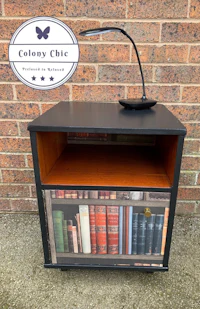 a nightstand with books on it and a lamp