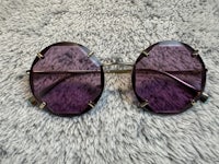 a pair of purple sunglasses on a fur rug