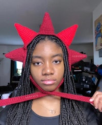 a woman wearing a crocheted red star hat